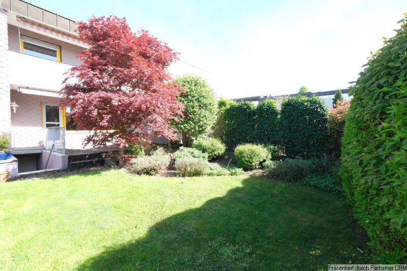 Garten mit Bäumen, Blühpflanzenbeet und Rasenfläche