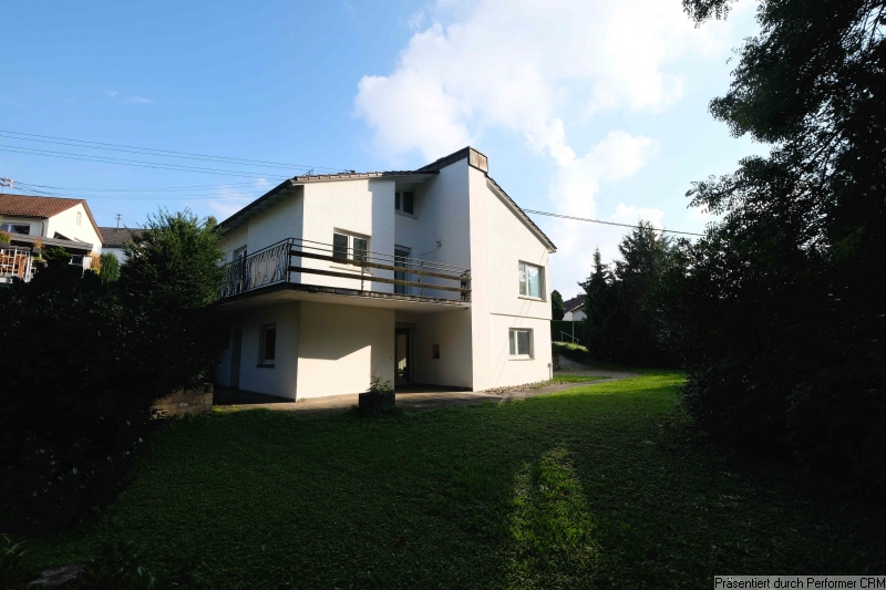 Hausansicht mit Garten und Wald